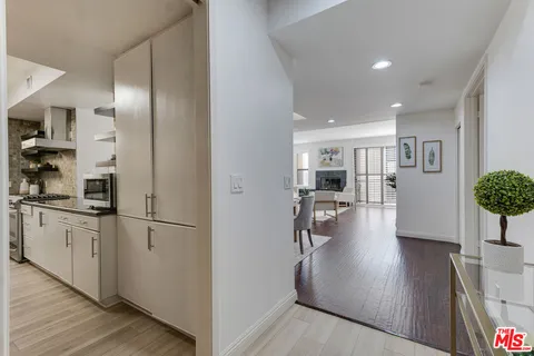 a open kitchen with white cabinets and stainless steel appliances