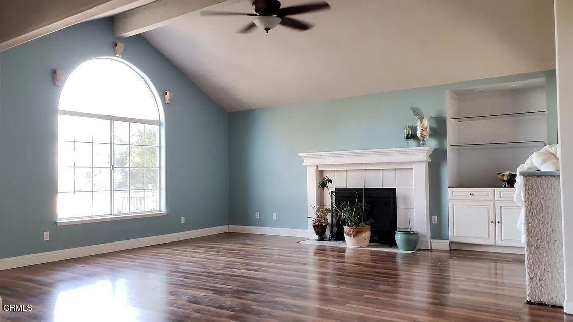 an empty room with fireplace wooden floor and windows