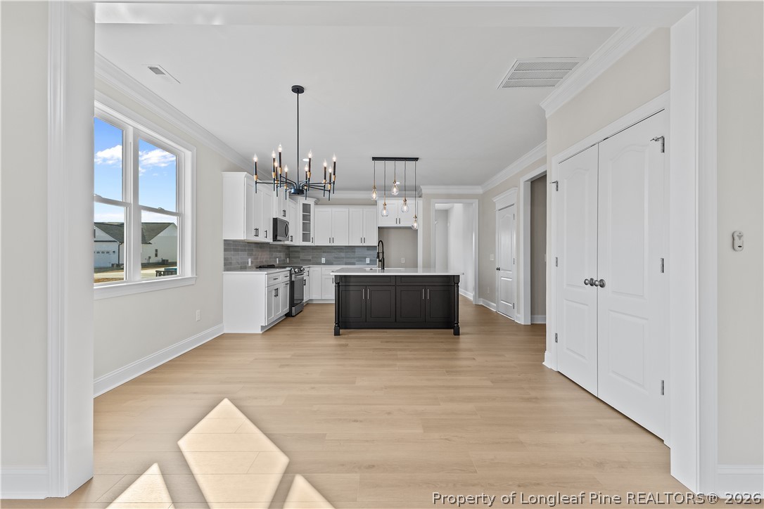 108 Sunny Acres Lane Clinton, NC 28328 - Photo 11 of 30 a view of a kitchen with kitchen island wooden floor and windows