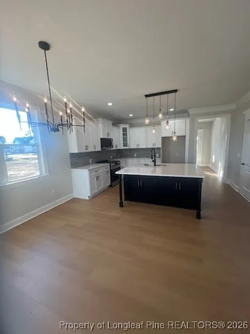 a view of an empty room and closet with wooden floor