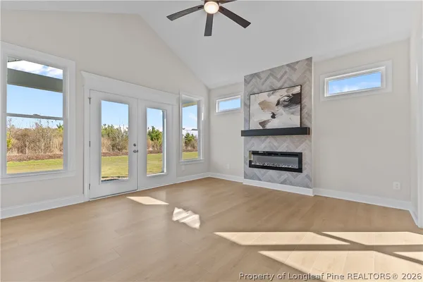 a view of an empty room with a window and a kitchen