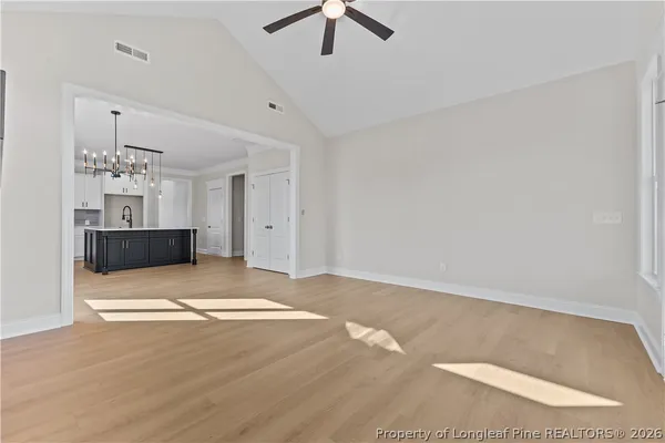 a view of livingroom with chandelier fan and kitchen view