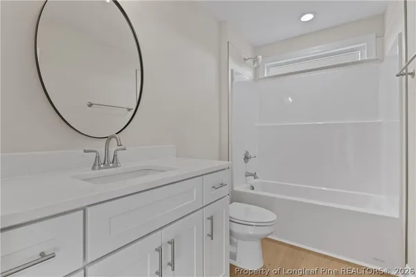 a bathroom with a granite countertop toilet a sink and a mirror