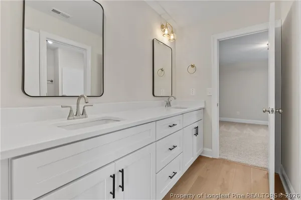 a bathroom with double sink and a mirror