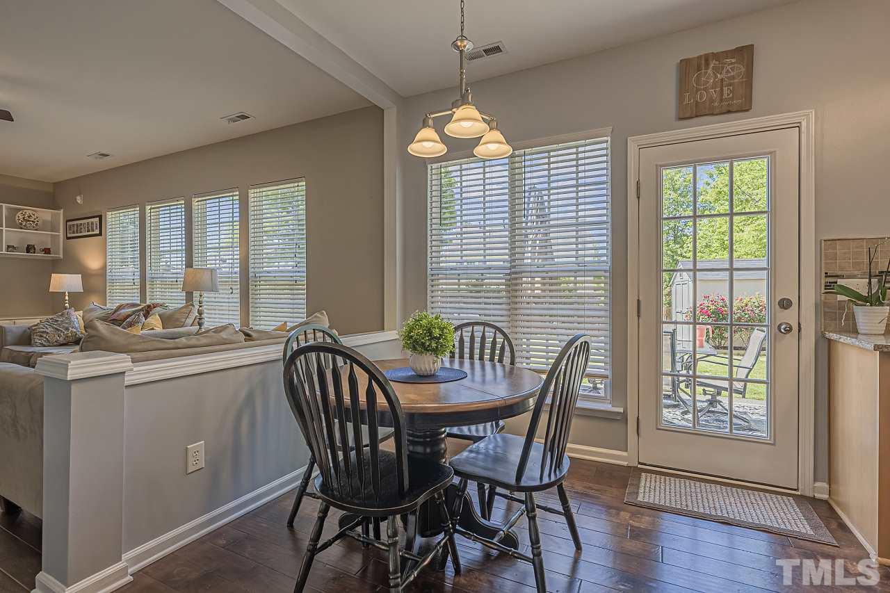 7759 San Gabriel Street Raleigh, NC 27613 - Photo 12 of 30 a dining room with furniture a chandelier and wooden floor