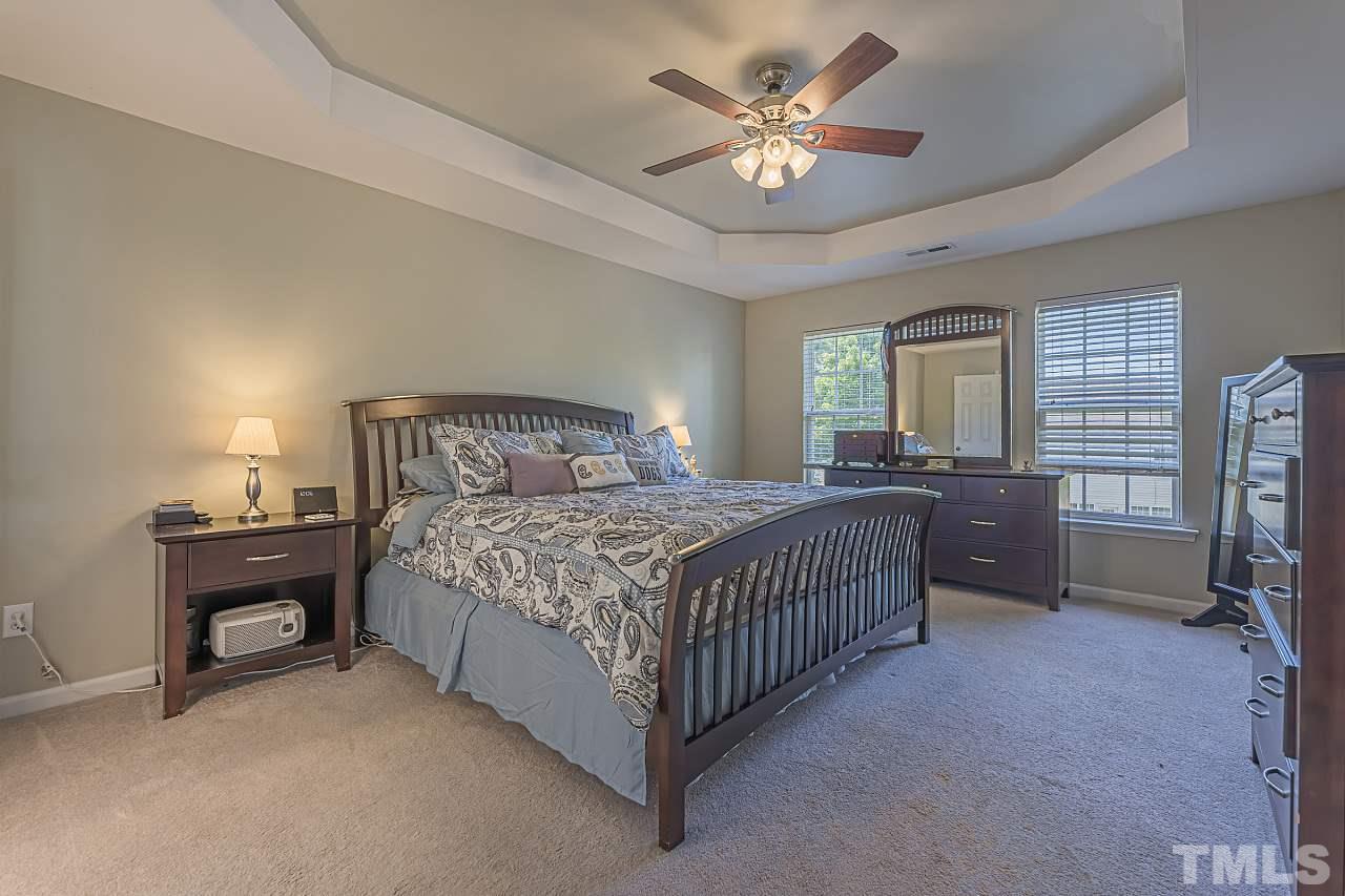 7759 San Gabriel Street Raleigh, NC 27613 - Photo 19 of 30 a bedroom with a bed and a chandelier