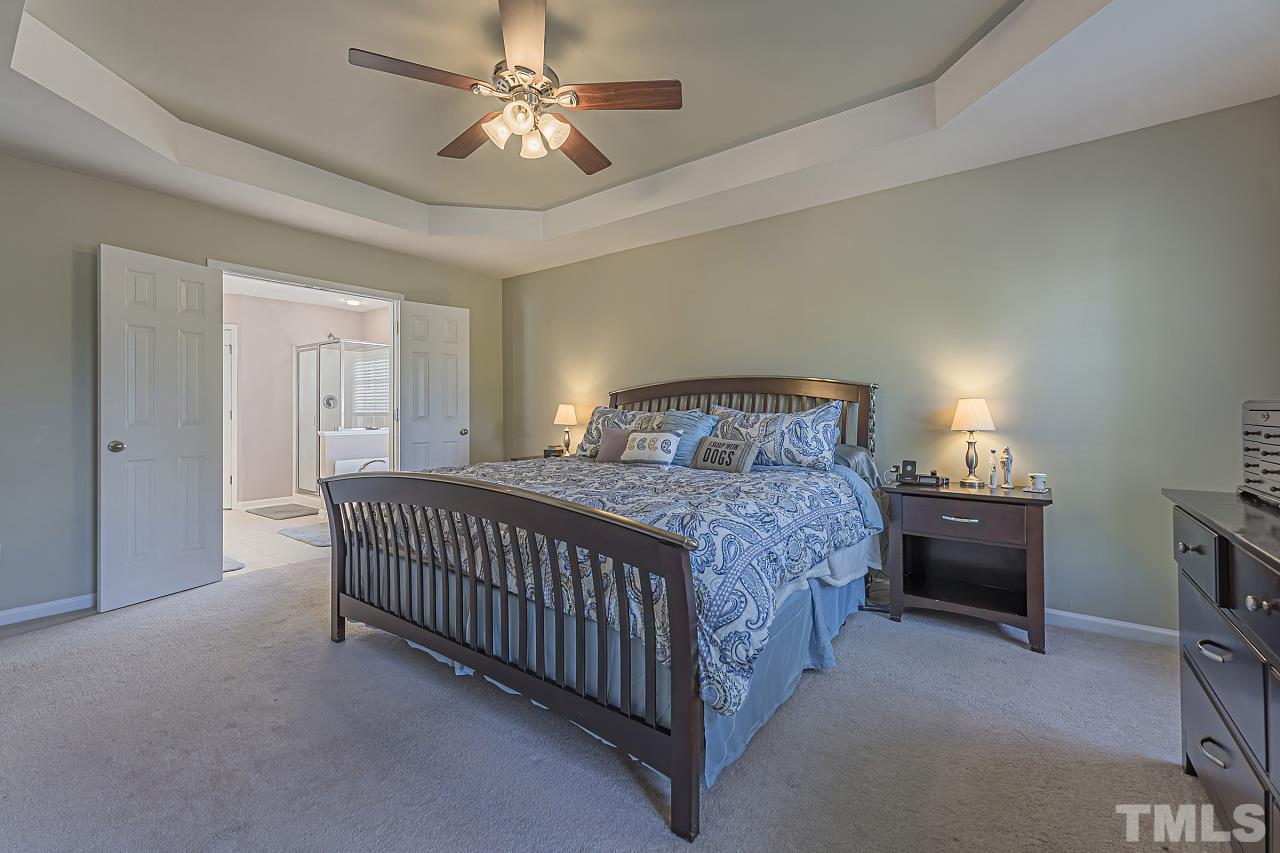 7759 San Gabriel Street Raleigh, NC 27613 - Photo 20 of 30 a bedroom with a bed and a chandelier