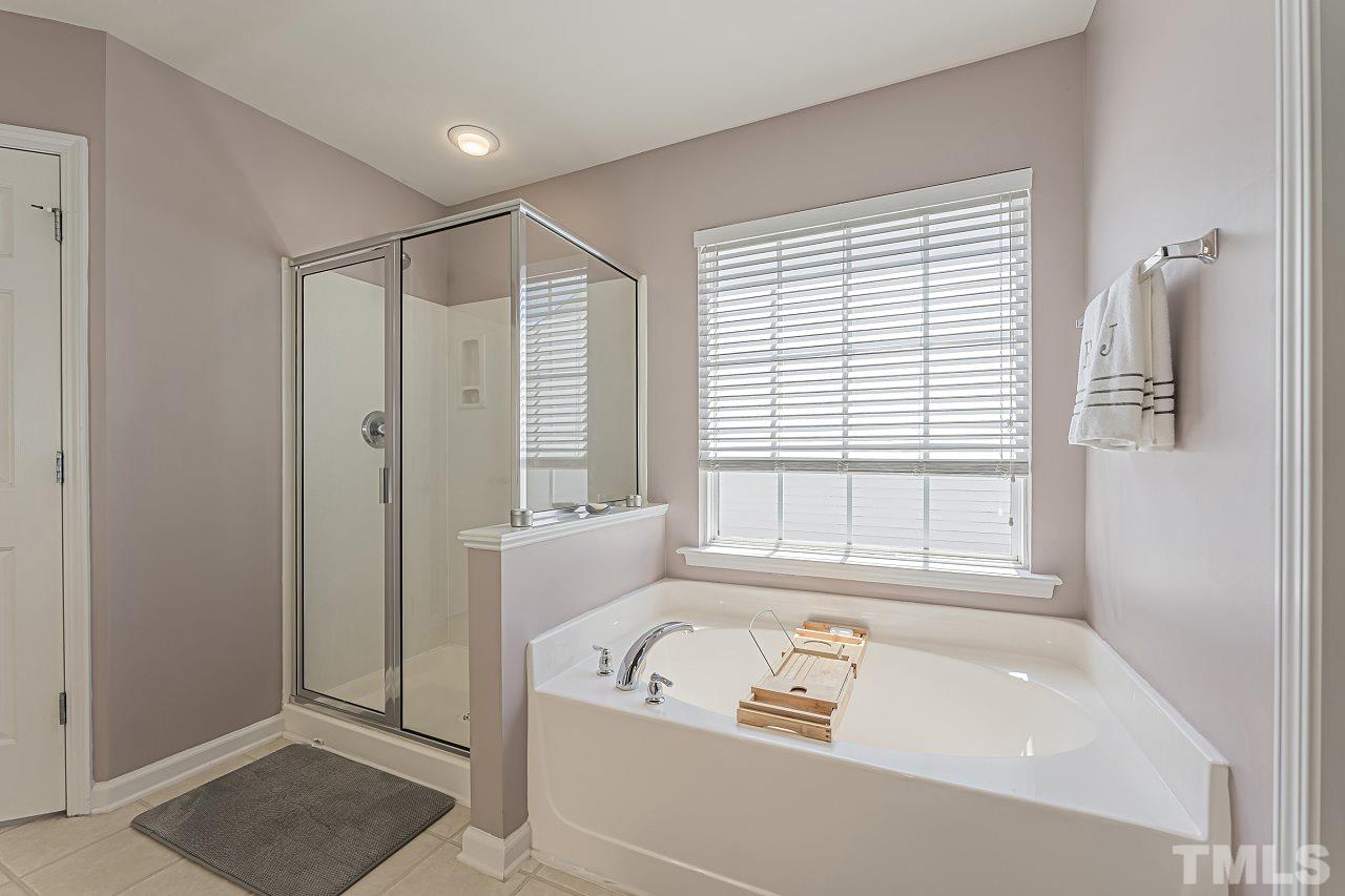 7759 San Gabriel Street Raleigh, NC 27613 - Photo 22 of 30 a bathroom with a tub a window and a shower
