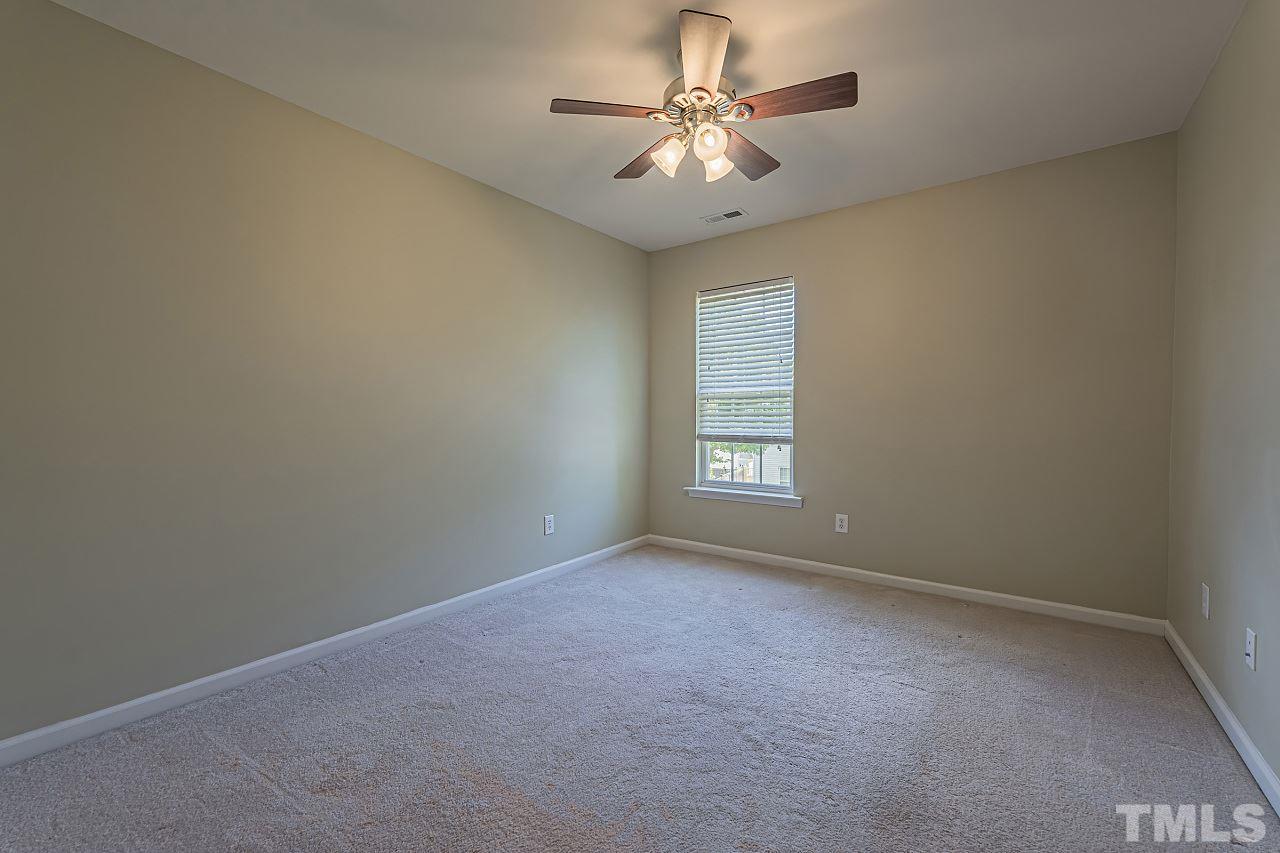 7759 San Gabriel Street Raleigh, NC 27613 - Photo 23 of 30 an empty room with a chandelier fan and windows