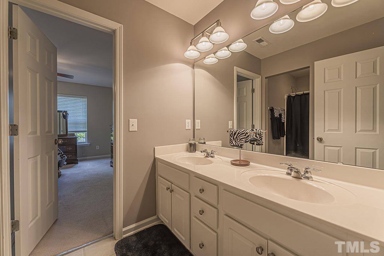 7759 San Gabriel Street Raleigh, NC 27613 - Photo 24 of 30 a en suite bathroom with a double vanity sink and a mirror
