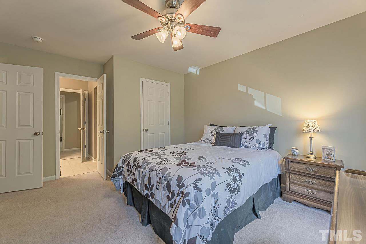 7759 San Gabriel Street Raleigh, NC 27613 - Photo 26 of 30 a bedroom with a bed and a chandelier