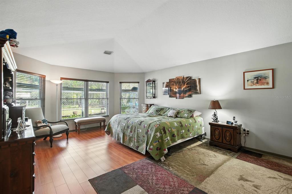 29933 Fullerville Road DeLand, FL 32720 - Photo 15 of 57 a spacious bedroom with a bed and glass windows