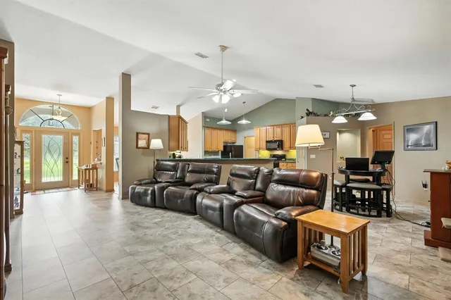a living room with furniture a chandelier and a dining table