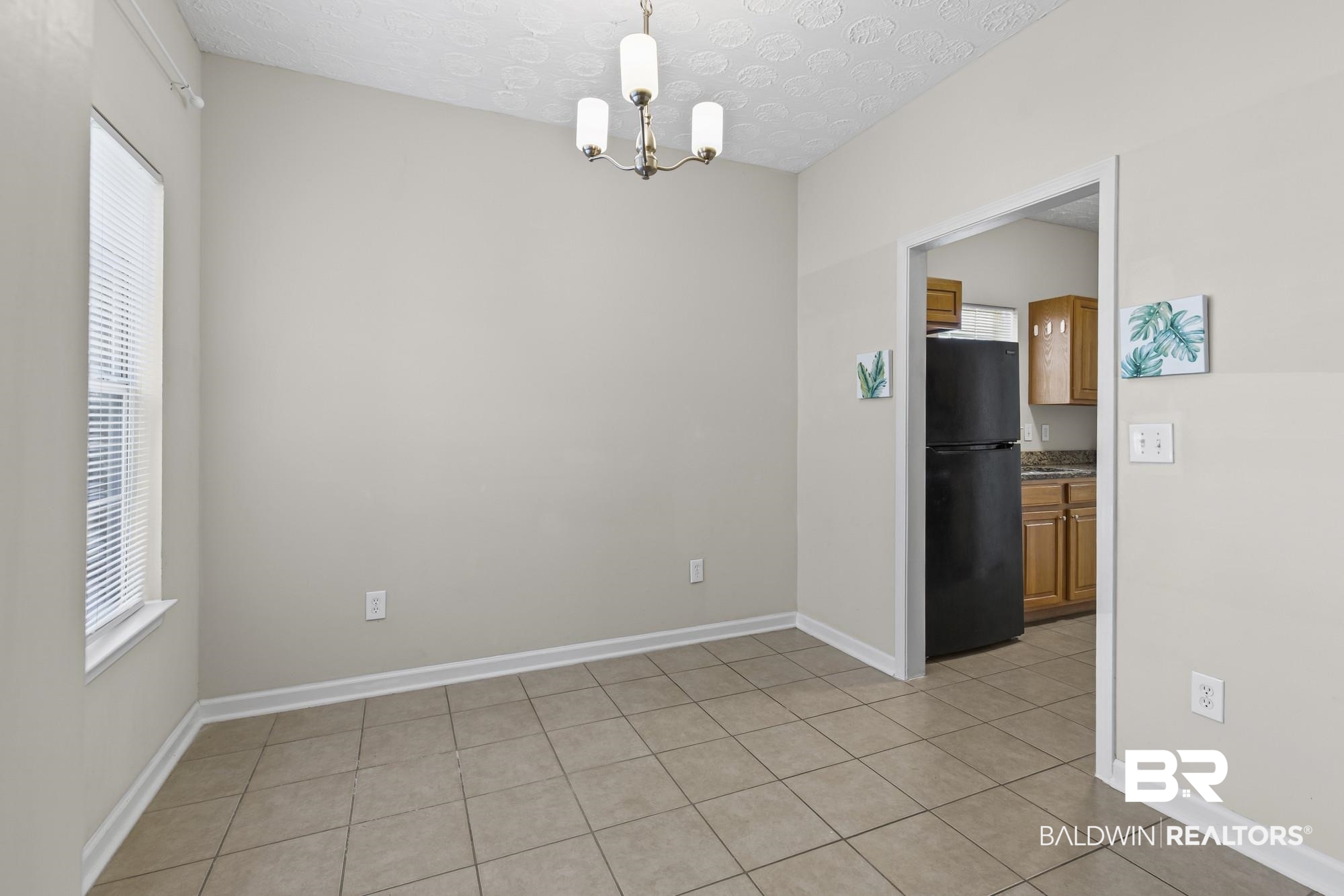 1153 Sloane Cove Foley, AL 36535 - Photo 8 of 25 Spare room with light tile patterned floors, hanging lights, and a textured ceiling