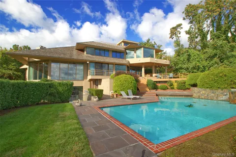 a view of a white house with a yard table and chairs