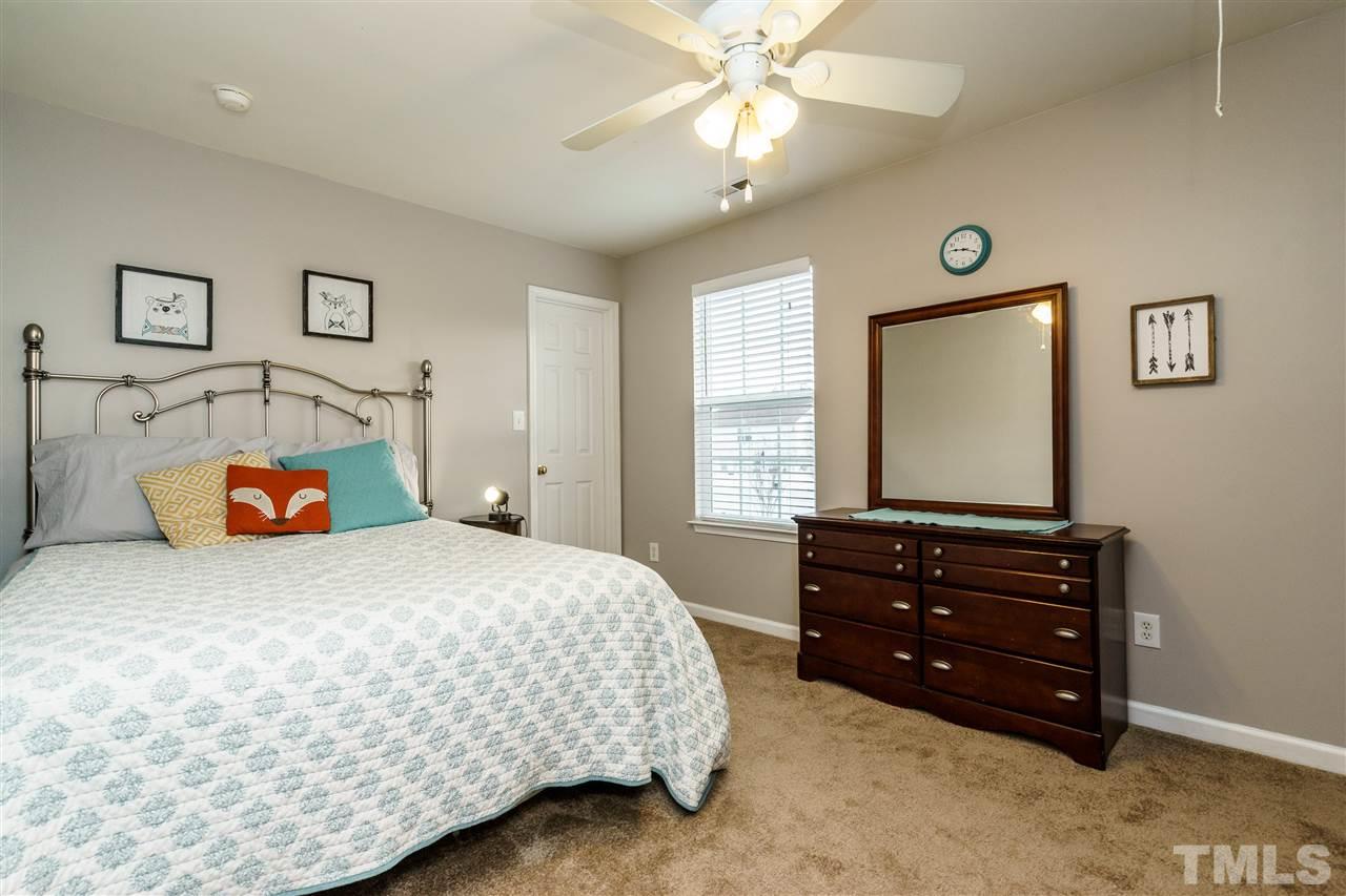 3809 Tyler Bluff Lane Raleigh, NC 27616 - Photo 22 of 25 a bedroom with a bed and a chandelier