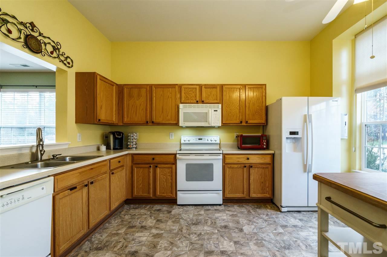 3809 Tyler Bluff Lane Raleigh, NC 27616 - Photo 5 of 25 a kitchen with stainless steel appliances granite countertop a sink a stove a refrigerator and cabinets