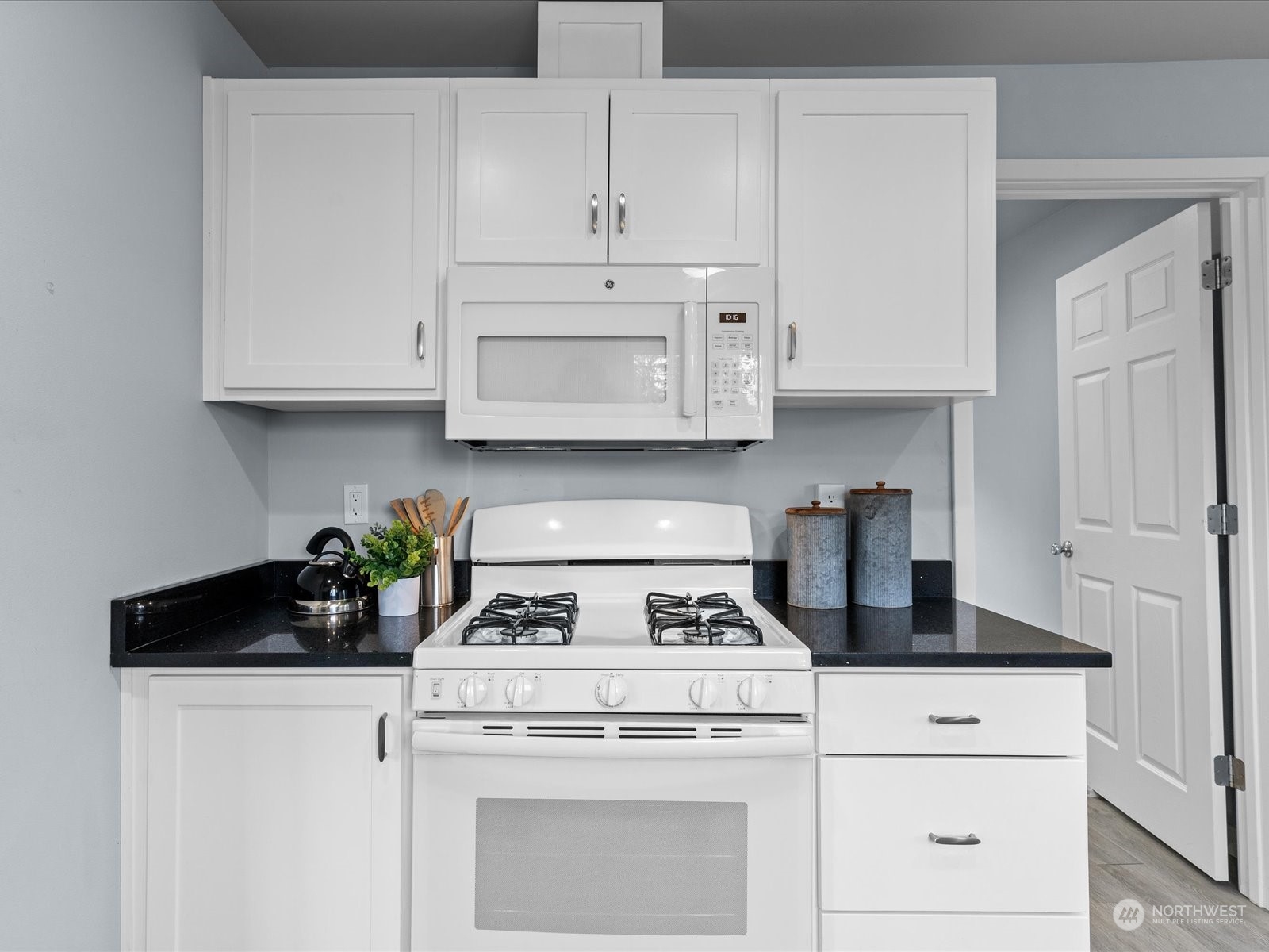 5514 Lowell Road Everett, WA 98203 - Photo 8 of 26 a kitchen with white cabinets and white appliances