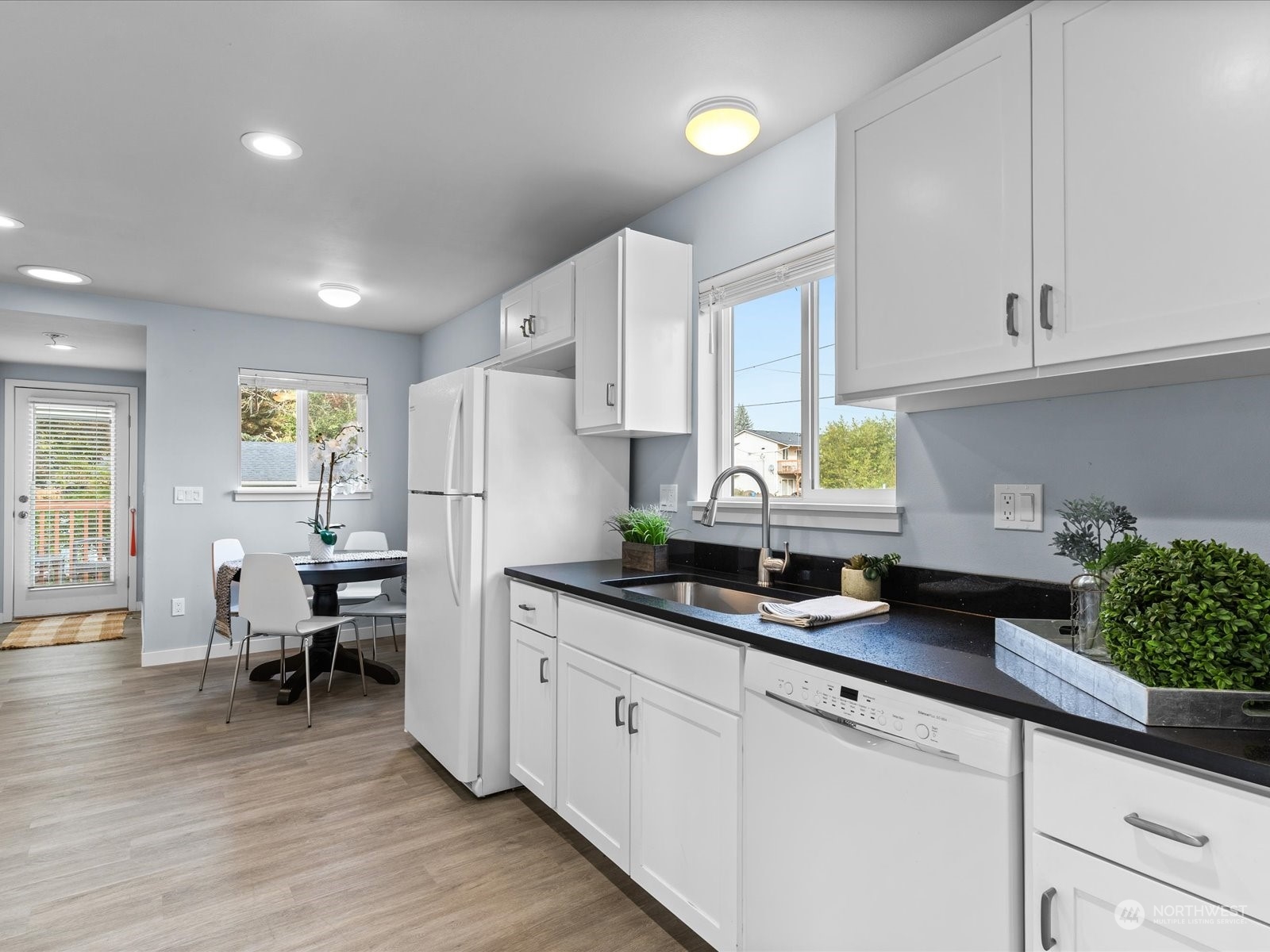 5514 Lowell Road Everett, WA 98203 - Photo 9 of 26 a kitchen with granite countertop white cabinets and wooden floor
