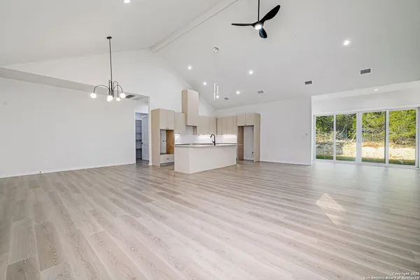a view of a room with kitchen and windows