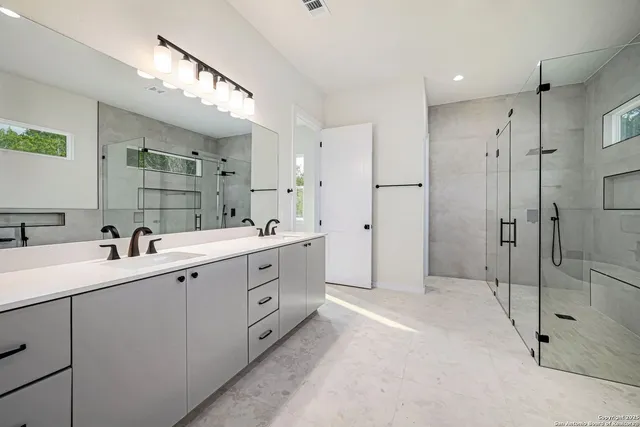 a bathroom with a shower sink and mirror