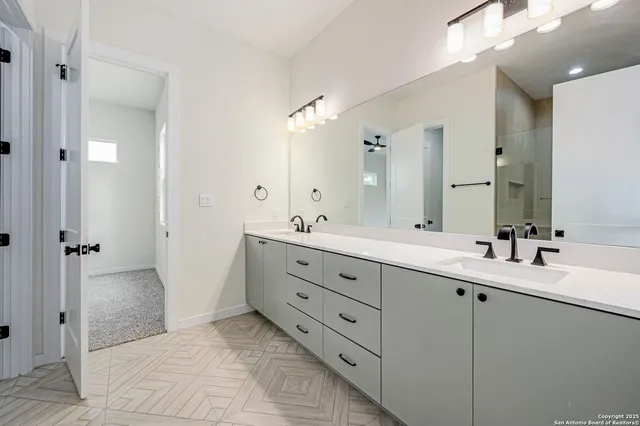 a spacious bathroom with double sink and a mirror