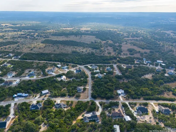 an aerial view of house with yard and mountain view in back