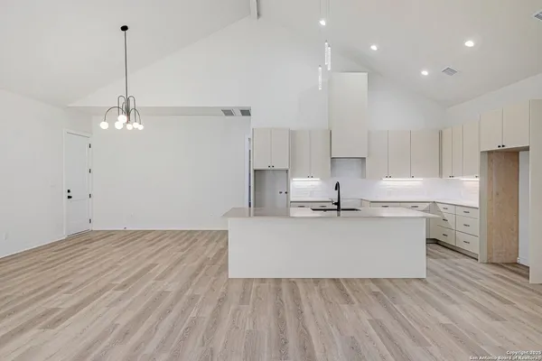 a large kitchen with kitchen island a sink stainless steel appliances and cabinets