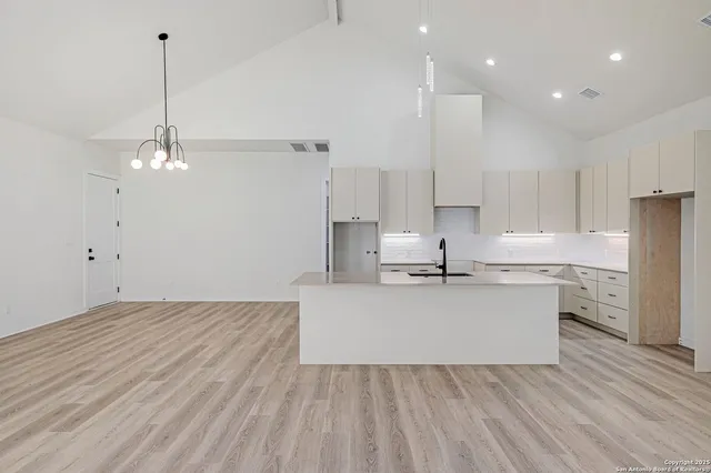 a large kitchen with kitchen island a sink stainless steel appliances and cabinets