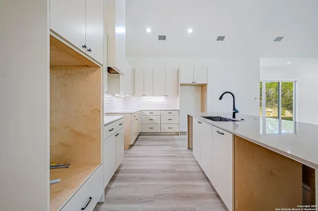a large kitchen with kitchen island a sink a stove and a refrigerator