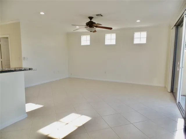 an empty room with windows and cabinet