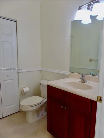 a bathroom with a toilet a sink and mirror