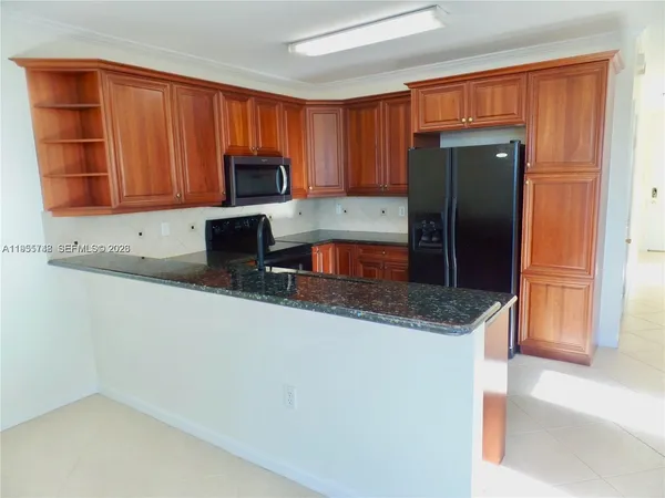 a kitchen with stainless steel appliances granite countertop a refrigerator and a sink