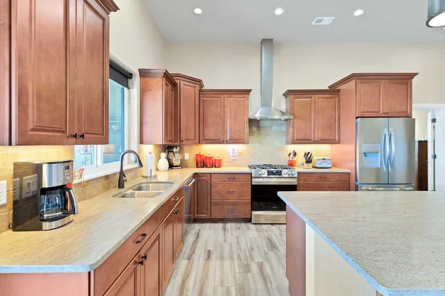 a kitchen with kitchen island granite countertop a sink stove and refrigerator