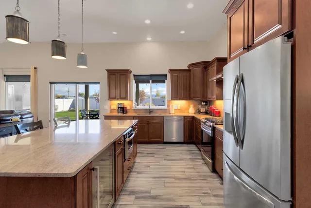 a kitchen with a refrigerator a sink and dishwasher with wooden floor