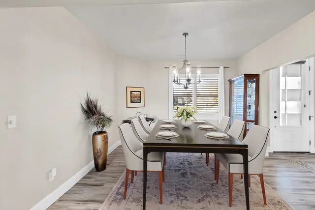 a view of a dining room with furniture a chandelier and wooden floor