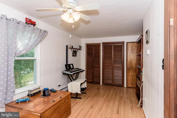 a view of storage and utility room with closet and wooden floor