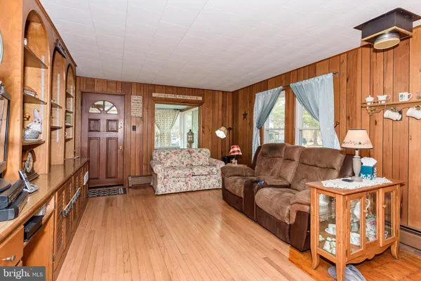 a living room with furniture a large window and wooden floor