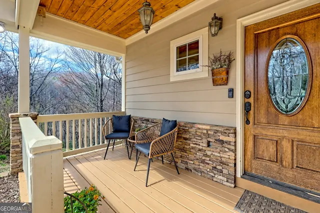 a view of a patio with table and chairs with wooden floor and fence