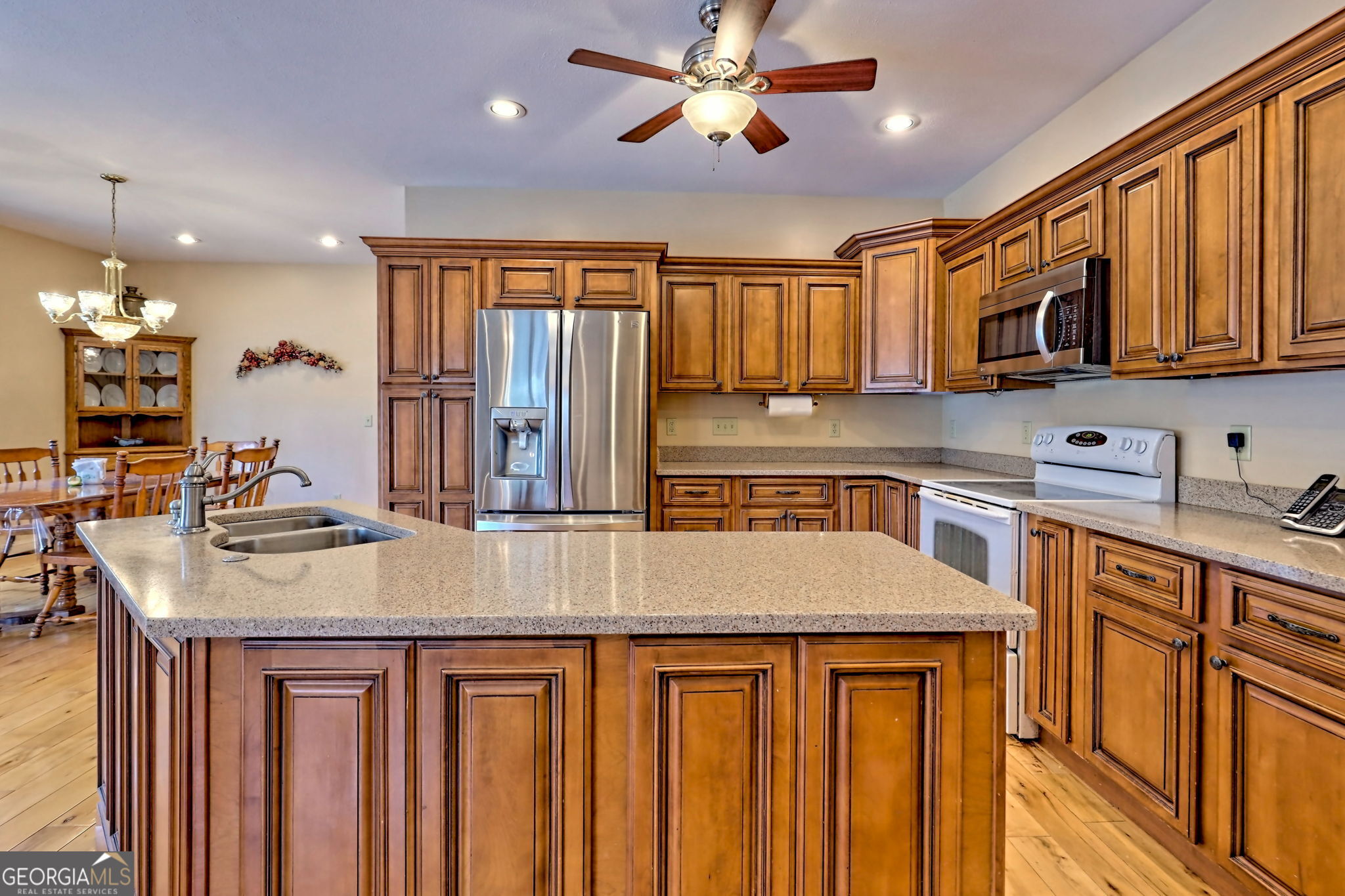 1068 Coleman River Road Clayton, GA 30525 - Photo 18 of 90 a kitchen with stainless steel appliances granite countertop a sink a microwave and wooden cabinets