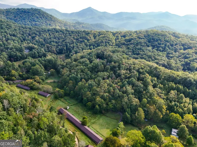 a kitchen with stainless steel appliances granite countertop a refrigerator a sink dishwasher a stove and white countertops with wooden floor