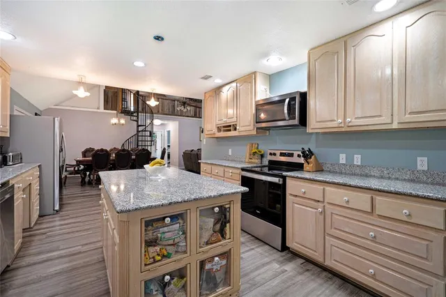 a kitchen with stainless steel appliances granite countertop a sink stove and refrigerator
