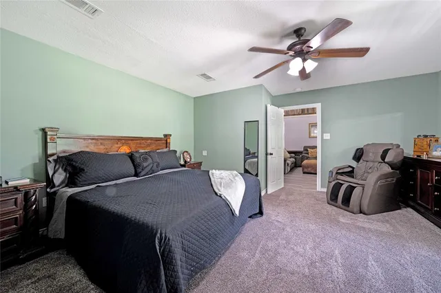 a bed room with a bed and a ceiling fan