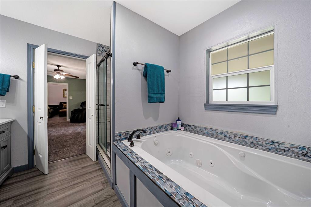 1511 North Walnut Grove Road Midlothian, TX 76065 - Photo 19 of 39 a bathroom with a bathtub and a shower