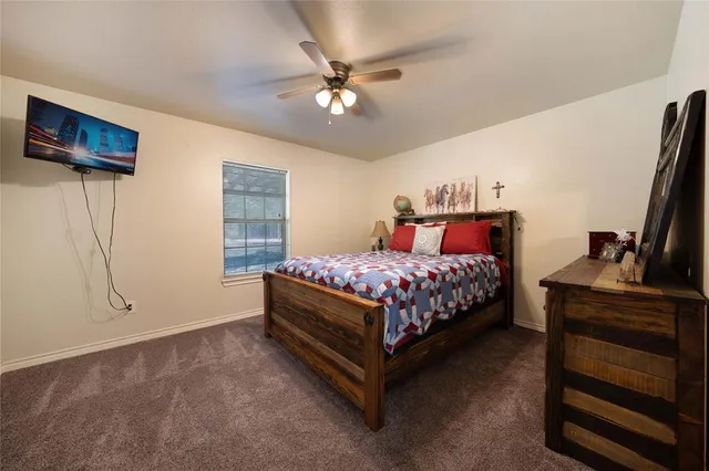 a bedroom with a bed and a flat tv screen on dresser