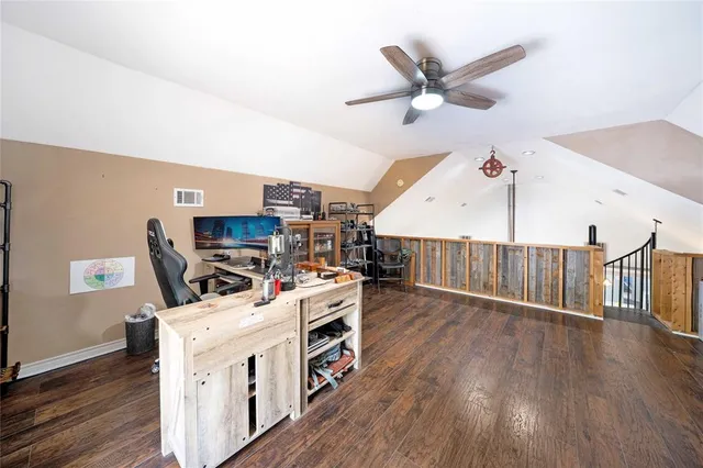 a work room with wooden floor and ceiling fan