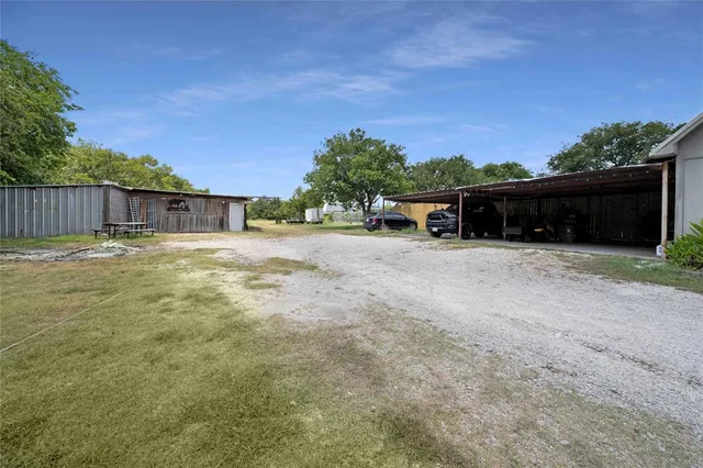 a view of a house with a yard and covered with wooden fence