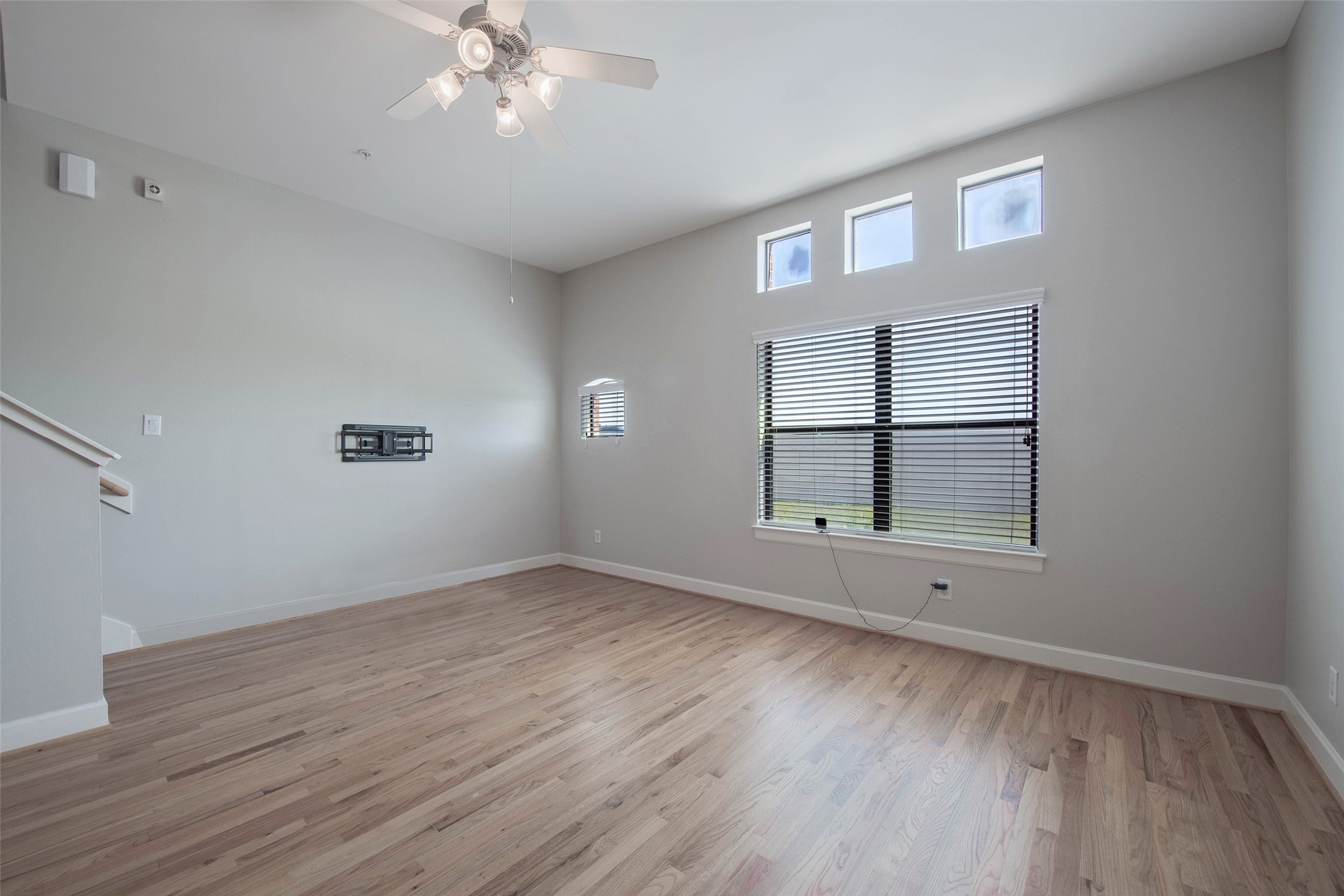 7650 Springhill Street, Unit 603 Houston, TX 77021 - Photo 7 of 26 an empty room with wooden floor chandelier and windows