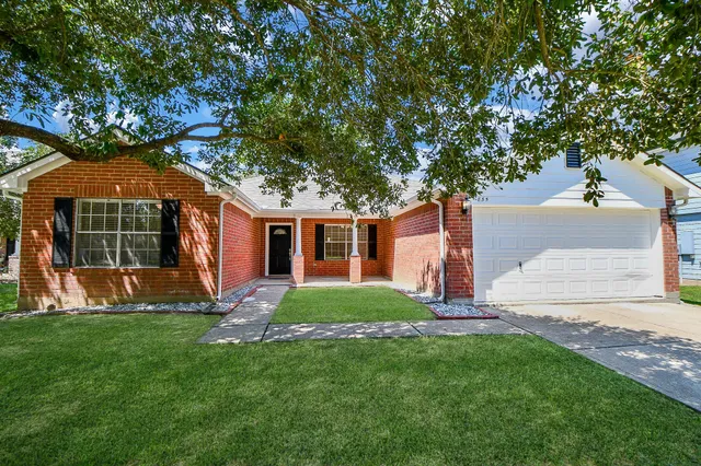 a front view of a house with a yard and trees