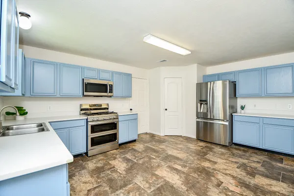 a kitchen with stainless steel appliances granite countertop a refrigerator stove top oven a sink and dishwasher